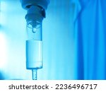 Small photo of Set IV fluid intravenous drop saline drip hospital room, ,medical concept, treatment patient emergency and injection drug infusion care. Blue light background hospital, Selective Focus.