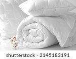 Two pillows and a folded blanket on a white background. Bedding items on a white background. Bedding catalog