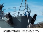 Small photo of New front of forecastle deck forward ship military ship gray color with rope, anchor alongside in port on sky blue background.