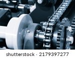 Gear chain drive shaft in conveyor belt is on production line. Timing chain of car, tensioners in engine. Industrial roller chain, technology. Team work, business industrial concept
