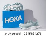 Small photo of Strasbourg, France - August 2023 : Hoka Bondi 8 new green running shoes and shoe box side ans sole view. Stylish monochrome shoes for active people that incorporate new health technology