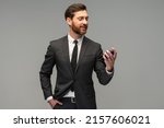 Small photo of Masculine bearded young man holding a generic bottle of perfume. Male fragrance and perfumery, cosmetics. Masculine perfume. Bearded man holding a bottle of perfume