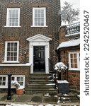 Small photo of London, UK - 12.12.2022. Facade of house at Holly Mount street view in Hampstead, London, England. Charming house facade, brick building. Winter in London. Snow in Hampstead. Snowing.