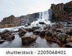 The beautiful Öxarárfoss waterfall flows from the river Öxará over black basalt rocks into the Almannagjá gorge, Þingvellir, Thingvellir National Park, Golden Circle Route, Iceland