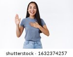 Small photo of Optimistic, honest and cute asian girl give oath, swear tell truth, put hand on heart and raise one arm as making promise, express devotion and declare telling only truth, stand white background