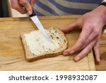 Knife spreading butter on toast ...