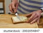 Woman hands spread bread with...