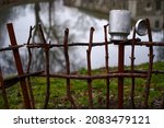 Metal can on the fence. Rural landscapes, traditional old clay pots on a wicker fence. metal milk container on the fence, a village tradition.