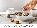Small photo of Italian traditional Carnival fritters toped with sugar powder is pouring to top, in white bowl on concrete background with carnival mask, sugar in jar. Sunny day light