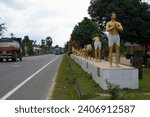 Small photo of Dharmanagar, Tripura, India. Dec.-23-2023. Yoga Posture of Surya Namaskar is being demonstrated with statues beside the highway to popularize the benefits of Yoga on maintaining good health.
