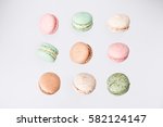 Colorful macarons cake, top view flat lay, fly falling sweet macaroon on color white isolated background. Minimal concepts falling macaroons pattern above, food background