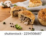 Small photo of Traditional Australian meat mini pie on the wooden background. Puff pastry pie with chicken and mushrooms. Savoury meat pie