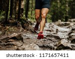 wet feet runner athlete running on trail stones in forest