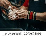 Small photo of male powerlifter applying gym chalk on his hands before bench press powerlifting competition