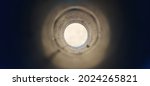 Small photo of Close-up deep endless round large and long concrete pipe hole with blurry black foreground and white background with copy space. Bore well, drainage, pipeline, mining and factory sewage concept.