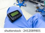 Small photo of vintage pager on a busy desk, symbolizing hectic work life and essential communication in a hospital setting