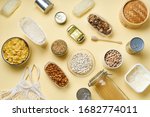 Small photo of Creative flatlay with pantry staples. Glass jars with pasta, beans and chickpeas, canned goods, nuts and dried mushrooms in reusable containers. Top view pattern with basic products