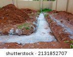 Small photo of concrete foundation of a building. heaps of soil that was dug up next to the foundations