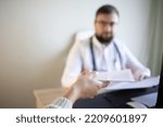 Small photo of Doctor with a beard and glasses transmits treatment prescriptions or recipe to the patient after consultation in the office. Panacea, prescribe treatment, legal drug store, contraception concept