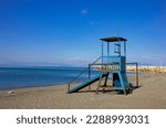 Small photo of Old metal Lifeguard Tower on empty beach. Lifeguard tower with seascape. Rusty, blue lifeguard tower.