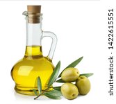 Small photo of Delicious olive oil in a glass bottle and green olives with leaves, isolated on white background