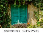 Small photo of Old unideal greenish closed window on wooden peeling wall of aged rustic building. Retro background of vintage wood house