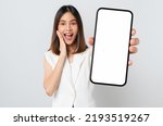 Studio shot of Beautiful Asian woman holding smartphone mockup of blank screen and smiling on white background.
