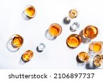 Strong alcoholic drinks, hard liquors, spirits and distillates in glasses: vodka, cognac, whiskey and other. White background. Hard light, copy space