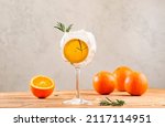 Small photo of Gin tonic cocktail long drink with dry gin, bitter tonic, orange, rosemary and ice. Wooden table background with copy space