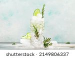 Small photo of Gin tonic with cucumber, alcoholic cocktail drink with dry gin, rosemary, tonic, fresh cucumber and ice cubes. Gray background, bar tools, copy space