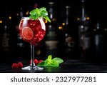 Small photo of Royal lemonade alcoholic cocktail drink with tequila, dry gin, white rum, vodka, liquor, lime, raspberries and ice in wine glass. Black bar counter background, bar tools and bottles