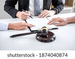 Small photo of Agreement prepared by lawyer signing decree of divorce (dissolution or cancellation) of marriage, husband and wife during divorce process with male lawyer or counselor and signing of divorce contract.