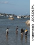 Small photo of Thursday 15 July 2021, Denpasar Bali Indonesia, The Atmosphere of Serangan Bay at low tide, boats are moored people go down to the sea looking for shells.