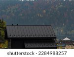 Small photo of House with new brown metal tile roof and rain gutter. Metallic Guttering System, Guttering and Drainage Pipe Exterior.