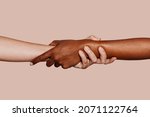 Close up multiracial woman couple with black and caucasian hands holding each other wrist in tolerance unity love and anti racism concept