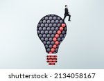 Businessman standing on abstract pattern light bulb on light background with mock up place. Idea, growth and success concept