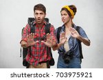 Small photo of Picture of stylish young European male and female tourists, travelers or adventures looking frustrated and worried, showing stop gesture with hands, trying to settle down conflict while traveling