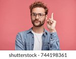 That is! Handsome clever student wonk or geek wears round glasses, raises finger as understands new theory, going to prove it, looks confidently, isolated over pink background. Confidence concept