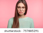 Small photo of Attractive Asian female has upset look, curves lower lip, being abused by someone, expresses dissatifaction and discontent, frowns face, displeased with results of exam, wants to retake, improve mark