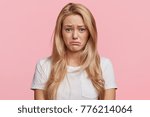 Portrait of displeased upset female frowns face as going to cry, being discontent and unhappy as can`t achieve goals, isolated over pink studio background. Dissapointed young woman has troubles