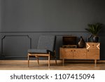 A gramophone on wooden cabinet and black chair in dark retro room interior