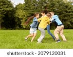 childhood, leisure and people concept - group of happy kids playing round dance at park