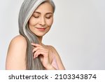 Portrait of gorgeous happy middle aged mature cheerful asian woman, senior older 50s lady pampering her hair eyes closed isolated on white. Ads of lifting anti wrinkle skin hair care spa. Copy space.