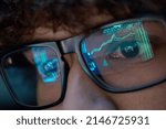 Small photo of Young indian business man trader wearing glasses looking at computer screen with trading charts reflecting in eyeglasses watching stock trading market financial data growth concept, close up.
