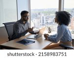 Small photo of Indian businessman ceo hr director having interview holding paper cv hiring for job female African American applicant sitting in contemporary office. Human resources recruitment concept.