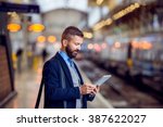 Hipster businessman with tablet, waiting, train platform