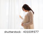 pregnancy, motherhood, people and expectation concept - close up of happy pregnant woman with big belly at window