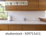 Wooden kitchen units and white worktop in modern interior