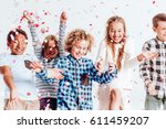 Happy kids throwing colorful confetti in a room