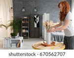 Young woman with red hair decorating contemporary fancy industrial apartment